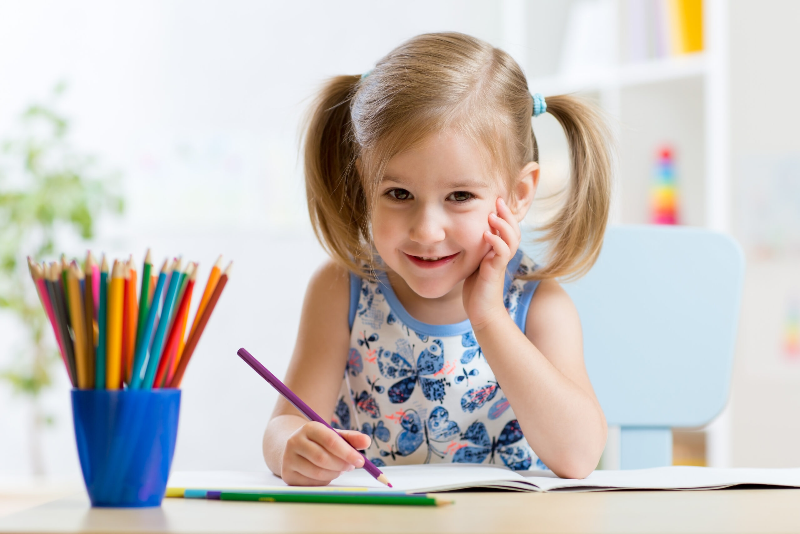 Cute little preschooler child drawing at home